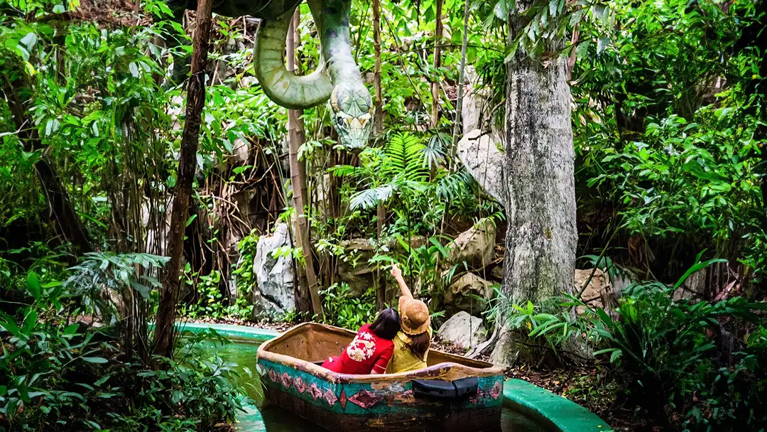 A themed boat attraction surrounded by tropical greenery